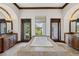 Luxurious bathroom with a large tiled tub, wood-trimmed mirrors, and views of the backyard at 1965 Lake Markham Preserve Trl, Sanford, FL 32771