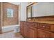 Bathroom featuring granite counters, wood cabinets, bronze fixtures, soaking tub and tile flooring at 1965 Lake Markham Preserve Trl, Sanford, FL 32771