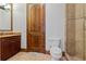 Bathroom with wood cabinets, granite counters, stand alone toilet and glass enclosed shower at 1965 Lake Markham Preserve Trl, Sanford, FL 32771