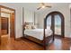 Comfortable bedroom with hardwood floors, a four-poster bed, and French doors to the outdoors at 1965 Lake Markham Preserve Trl, Sanford, FL 32771