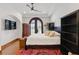 Bedroom featuring a ceiling fan, arched doorway leading to water view and dark wood furnishings at 1965 Lake Markham Preserve Trl, Sanford, FL 32771