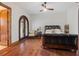 Bedroom with hardwood floors, a dark wood bed, and a curved door leading to the outside at 1965 Lake Markham Preserve Trl, Sanford, FL 32771