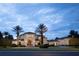 Stunning two-story home with a tile roof and palm trees in the front at 1965 Lake Markham Preserve Trl, Sanford, FL 32771