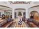 Elegant living room featuring a grand foyer, travertine floors, and comfortable leather seating at 1965 Lake Markham Preserve Trl, Sanford, FL 32771