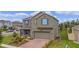 Two-story house with blue shutters and a brick driveway at 2003 American Beech Pkwy, Ocoee, FL 34761