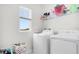 Bright laundry room with washer, dryer, and ample shelving at 2003 American Beech Pkwy, Ocoee, FL 34761