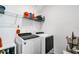 A well-equipped laundry room with white washer and dryer set, storage shelf, and a wire basket at 15259 Willow Arbor Cir, Orlando, FL 32824