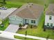 Aerial view of a one-story home with a brick driveway, manicured lawn, and nearby lake at 2585 Cavanaugh Dr, Orlando, FL 32817