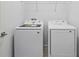 Functional laundry room featuring a modern washer and dryer with a wire rack above at 2585 Cavanaugh Dr, Orlando, FL 32817