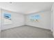 A light-filled bedroom showcasing neutral carpet, two windows, and minimalist modern design at 1694 Pinecliff Dr, Apopka, FL 32703