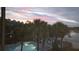 A community pool and beach cabana are framed by palm trees under a colorful sunset at 4113 Fairview Vista Pt # 308, Orlando, FL 32804