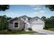 Charming single-story home featuring stone accents, neutral colors, a two-car garage, and professionally landscaped yard at 1685 Andover Ridge Dr, Deland, FL 32720