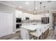 Modern kitchen featuring white cabinets, large island with seating, stainless steel appliances, and wood-look flooring at 1685 Andover Ridge Dr, Deland, FL 32720