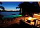 Evening shot of the outdoor living space with fire pit and lakeside illuminated pool at 1010 Strathmore Dr, Orlando, FL 32806
