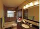 Cozy bathroom featuring a shower-over-tub, granite vanity, and attractive sconce lighting at 1010 Strathmore Dr, Orlando, FL 32806