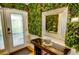 Stylish entryway with lush greenery wall, elegant mirror, and modern console table at 1010 Strathmore Dr, Orlando, FL 32806