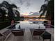 Relaxing lakeside pool with lounge chairs and a scenic view of the sunset on the water at 1010 Strathmore Dr, Orlando, FL 32806