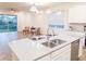 Modern kitchen with a view into the living area, featuring an island with stainless steel appliances at 886 Grazie Loop, Davenport, FL 33837