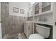 Clean bathroom with white vanity, wood-look tile, and a glass-front cabinet at 2874 Autumn Green Dr, Orlando, FL 32822