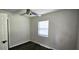Simple bedroom with window, ceiling fan, and dark wood floors at 3408 Lewis Ct, Orlando, FL 32805