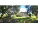 View of the backyard featuring an outbuilding, shaded by large trees at 2661 Waccassa St, Geneva, FL 32732
