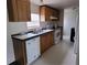 Galley kitchen featuring white appliances, wood cabinets, and a sink under a window at 2661 Waccassa St, Geneva, FL 32732