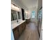 Modern bathroom featuring double vanities, sleek mirrors, and wood-look tile flooring at 282 Kimble Ave, Oviedo, FL 32765