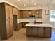Spacious kitchen boasts an island, modern lighting, and wood-look tile flooring at 282 Kimble Ave, Oviedo, FL 32765