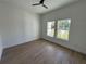 Well-lit bedroom with wood-look tile flooring and a view of the outdoors through two windows at 292 Kimble Ave, Oviedo, FL 32765
