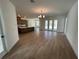 Open-concept living room with wood-style tile flooring and a view of the kitchen and outdoor space at 292 Kimble Ave, Oviedo, FL 32765