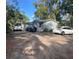 Modest one-story home with grey siding and three cars parked on a gravel driveway at 1149 Holden Ave, Orlando, FL 32839