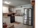 Well-equipped kitchen featuring white cabinetry, modern appliances, and stainless steel refrigerator at 1149 Holden Ave, Orlando, FL 32839