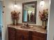 Bathroom sink with granite countertops, decorative flowers, and framed mirror at 3336 Edgecliffe Dr, Orlando, FL 32806
