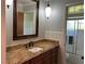 Bathroom with granite countertop, under-mount sink, and a framed mirror above the vanity at 3336 Edgecliffe Dr, Orlando, FL 32806