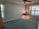 Neutral bedroom featuring a ceiling fan, carpeted floor, and windows dressed with white curtains at 3336 Edgecliffe Dr, Orlando, FL 32806