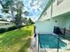 Backyard showcasing a personal pool with safety fencing, plus a lush green lawn extending to neighboring properties at 7944 Formosa Valley Pl, Kissimmee, FL 34747