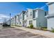 Row of townhomes featuring modern architectural design, manicured landscaping, and ample parking at 7944 Formosa Valley Pl, Kissimmee, FL 34747