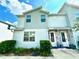 Exterior view of the townhome featuring stone accents and a well-maintained lawn at 7944 Formosa Valley Pl, Kissimmee, FL 34747
