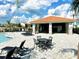 Exterior view of the community pool area featuring a covered seating area with tables and chairs at 7944 Formosa Valley Pl, Kissimmee, FL 34747