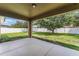 Backyard featuring a covered patio with a concrete floor and view of the large, fenced yard with a mature tree at 2134 Osprey Woods Cir, Orlando, FL 32820