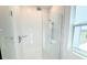 Modern bathroom featuring a glass-enclosed shower with rain shower head and sleek fixtures at 14771 Erice Ave, Clermont, FL 34714