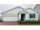 Charming single-Gathering home featuring a brick driveway, attached garage, and well-maintained landscaping at 14771 Erice Ave, Clermont, FL 34714