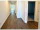 Well-lit hallway featuring modern wood flooring and neutral walls, leading to various rooms in the house at 14771 Erice Ave, Clermont, FL 34714
