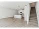 Bright kitchen and staircase with tile floors, white cabinets, and stainless steel appliances at 4308 Ranch House Rd, Saint Cloud, FL 34772