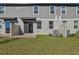 A manicured backyard with a red brick patio, exterior entrance, gray siding, and green grass at 4368 Ranch House Rd, Saint Cloud, FL 34772