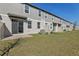 View of several backyards, each with patios, gray siding, grassy yards, and exterior entrances at 4368 Ranch House Rd, Saint Cloud, FL 34772