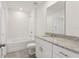 Modern bathroom featuring granite countertops, white cabinets, and a shower-tub combo with tile surround at 4368 Ranch House Rd, Saint Cloud, FL 34772