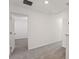 Hallway with neutral carpet, white walls, and a view into another room at 4368 Ranch House Rd, Saint Cloud, FL 34772