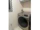 Laundry room with modern, front-load washing machine and upper shelving for storage at 1909 Summer Club Dr # 307, Oviedo, FL 32765