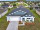 One-story house with gray roof and blue accents, a white garage door, and landscaping at 4902 Pall Mall E St, Kissimmee, FL 34758